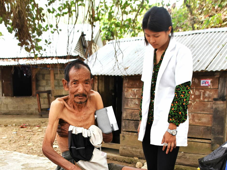 Unsere Pflegefachfrau Birsana misst mit dem elektronischen Messgerät Blutdruck und Herzströme bei einem Patienten (Health Camp Biman, März 2022)